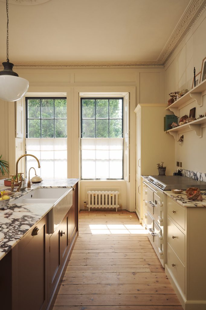 posttitle | sitetitle Bright traditional kitchen with marble counters cream cabinets and large windows above the sink