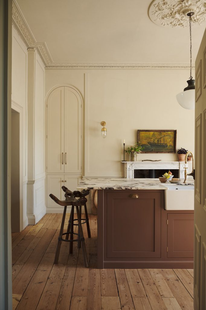posttitle | sitetitle Classic cream kitchen with marble island ornate ceiling molding and a painting above the mantel